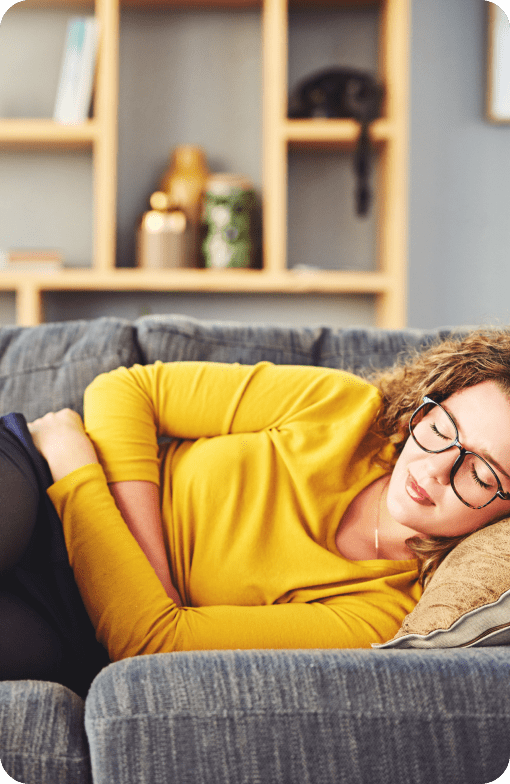 Woman resting on couch in yellow shirt