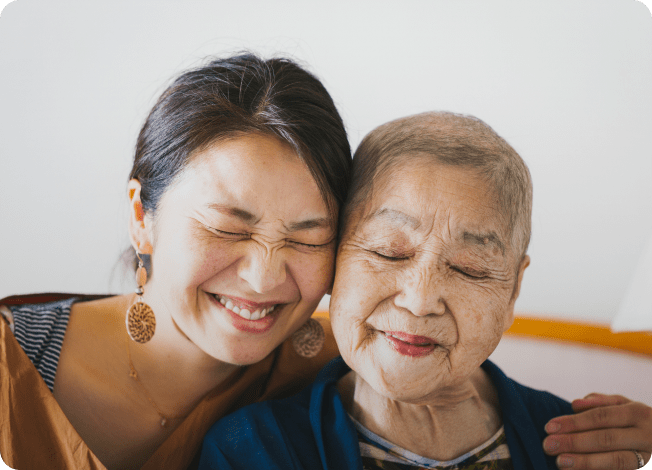 Two women hugging and smiling with their eyes closed
