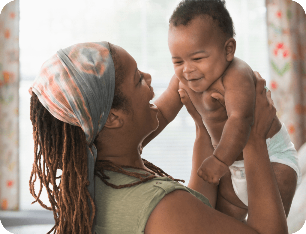 Woman holding up and laughing with her baby